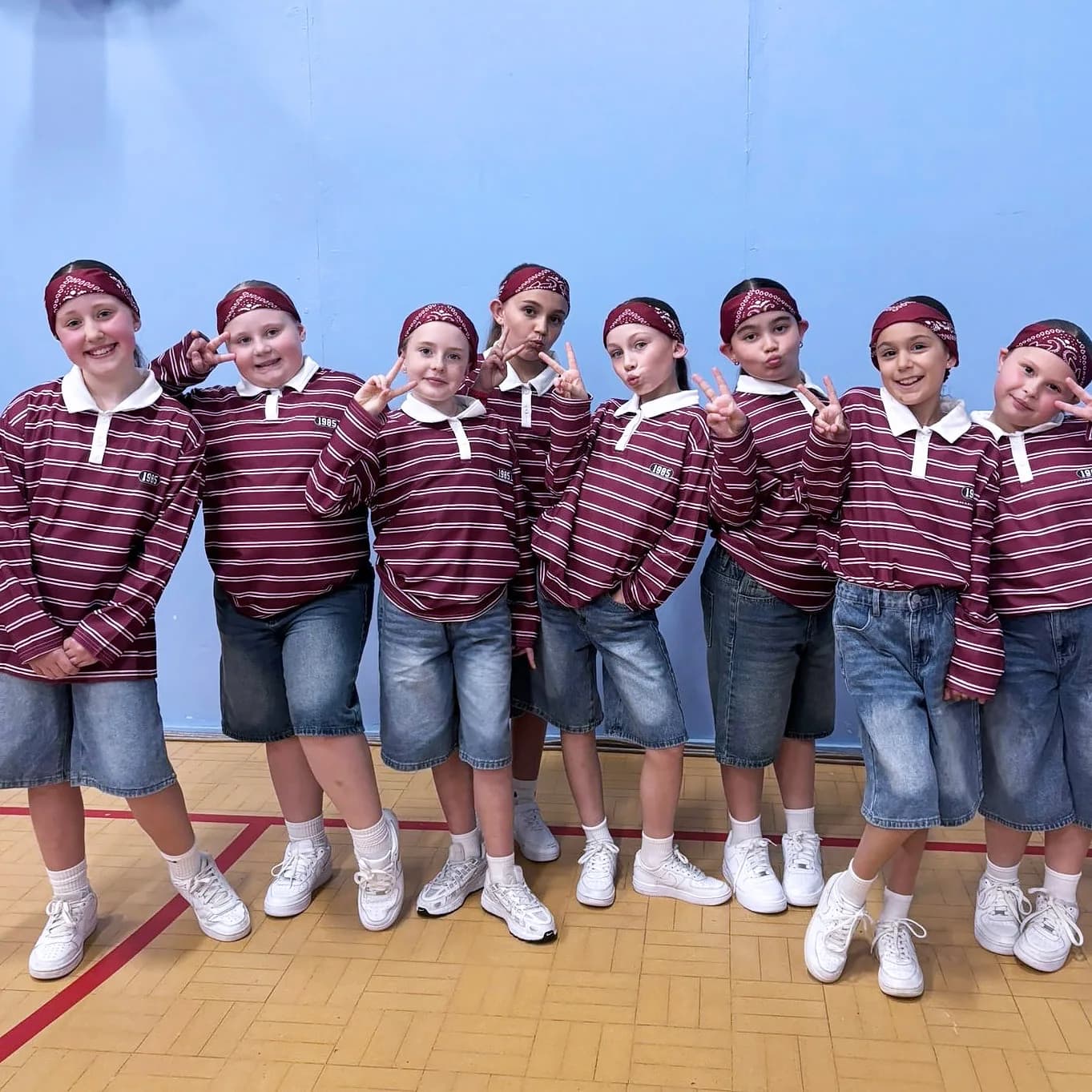 HK Elite Team competition troupe in matching maroon 1985 rugby shirts and red bandanas, ready to compete.